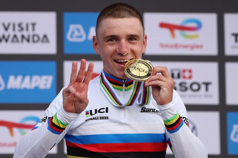 Gold medallist Belgian rider Remco Evenepoel bites his medal on the podium following the men's Elite Individual Time Trial cycling event during the UCI 2025 Road World Championships, in Kigali, on September 21, 2025.  Anne-Christine POUJOULAT / AFP
