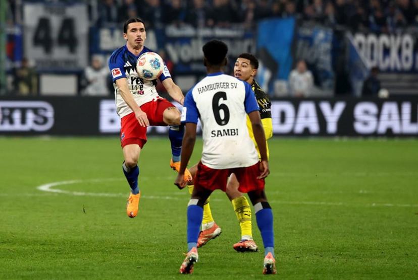(L-R) Hamburg's French forward #14 Rayan Philippe, Hamburg's Belgian-Congolese midfielder #06 Albert Sambi Lokonga and Dortmund's English midfielder #07 Jobe Bellingham vie for the ball during the German first division Bundesliga football match between Hamburger SV and Borussia Dortmund in Hamburg, northern Germany on November 8, 2025.  Ibrahim OT / AFP