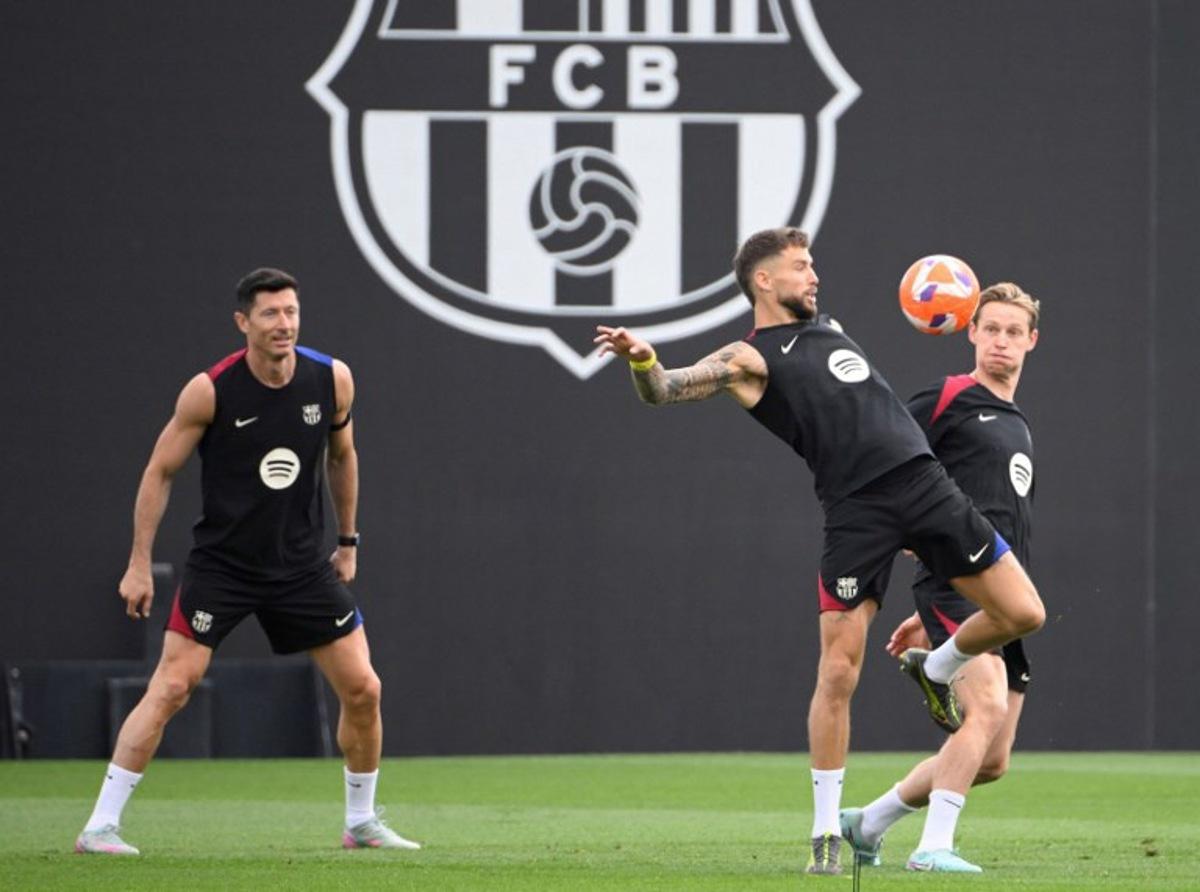(From L) Barcelona's Polish forward #09 Robert Lewandowski, Barcelona's Spanish defender #05 Inigo Martinez Berridi, Barcelona's Dutch midfielder #21 Frenkie De Jong take part in a training session on the eve of the Spanish league football match between FC Barcelona and Real Madrid CF, at the Joan Gamper training ground in Sant Joan Despi, near Barcelona, on May 10, 2025.  Josep LAGO / AFP