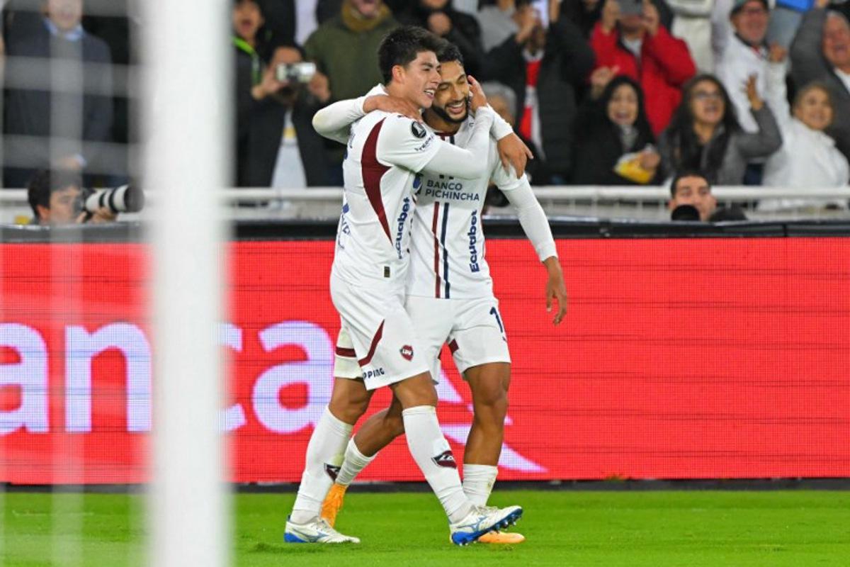 Liga de Quito's Bolivian midfielder #15 Gabriel Villamil (L) celebrates with teammate Colombian forward #16 Jeison Medina scoring his team's third goal during the Copa Libertadores semifinal first leg football match between Ecuador's Liga de Quito and Brazil's Palmeiras at the Rodrigo Paz Delgado stadium in Quito on October 23, 2025.  Rodrigo BUENDIA / AFP