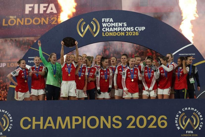 Arsenal players celebrate with the trophy at the presentation after the FIFA Women's Champions Cup final football match between Arsenal and Corinthians at the Emirates Stadium in London on February 1, 2026. Arsenal won the game 3-2 after extra time. Adrian Dennis / AFP