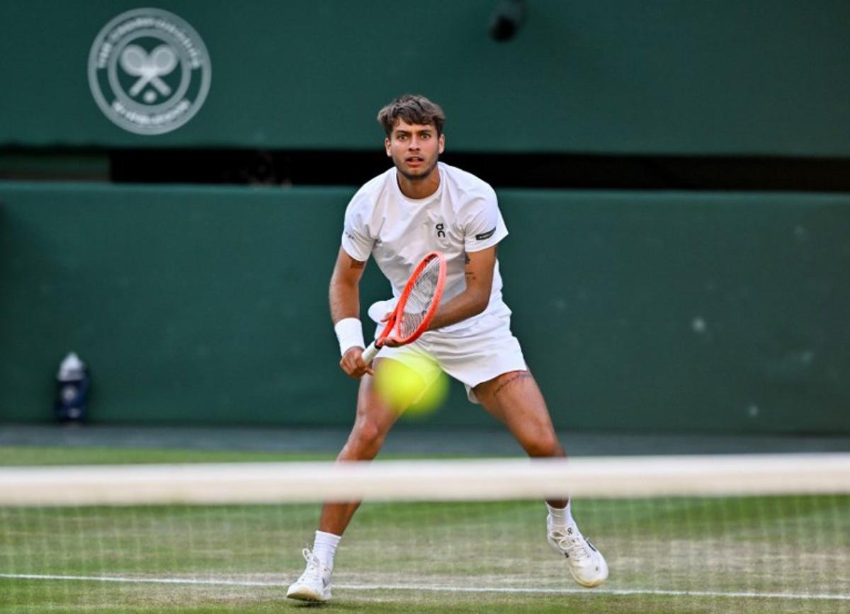 Italy's Flavio Cobolli returns the ball to Serbia's Novak Djokovic during their men's singles quarter-final tennis match on the tenth day of the 2025 Wimbledon Championships at The All England Lawn Tennis and Croquet Club in Wimbledon, southwest London, on July 9, 2025.  Glyn KIRK / AFP