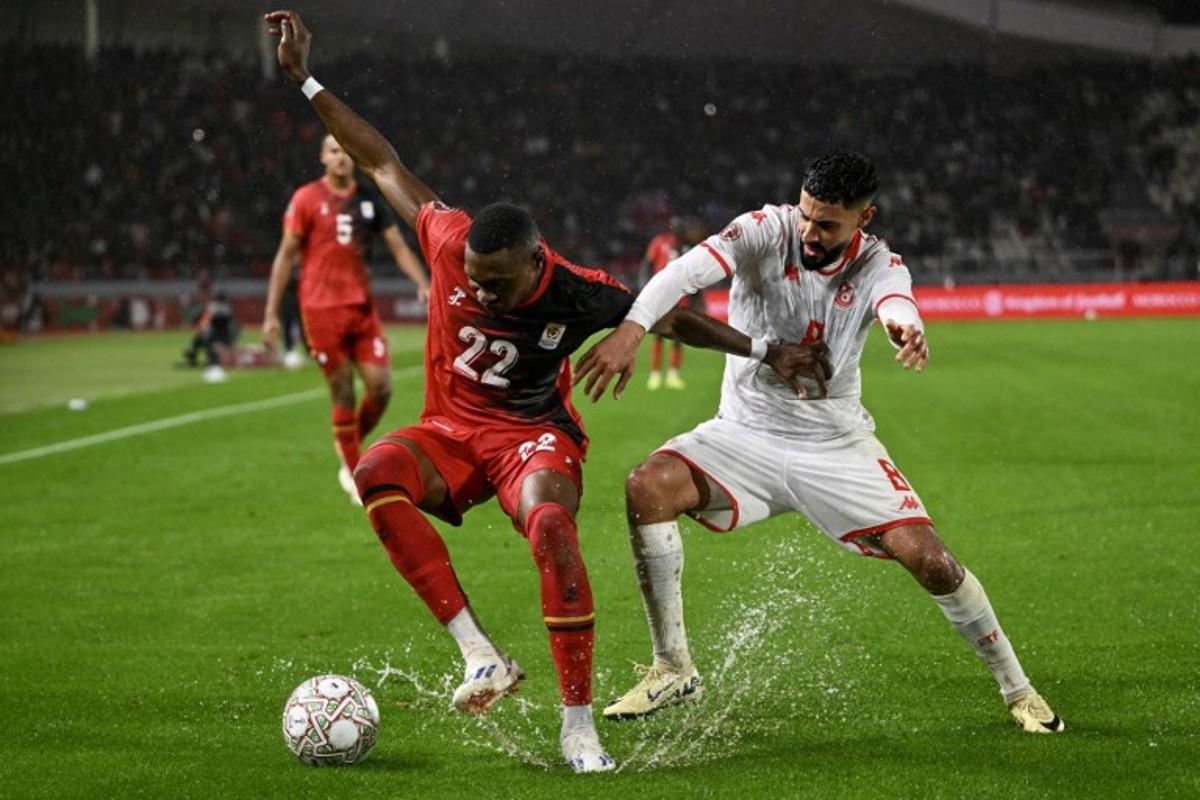 Uganda's forward #22 Jude Ssemugabi and Tunisia's forward #08 Elias Saad vie during the Africa Cup of Nations (CAN) Group C football match between Tunisia and Uganda at Rabat Olympic Stadium in Rabat on December 23, 2025.   SEBASTIEN BOZON / AFP