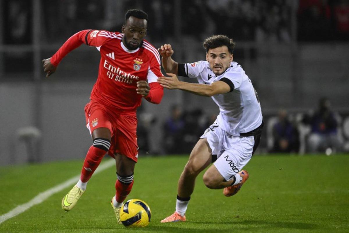 SL Benfica's Belgian forward #11 Dodi Lukebakio and Vitoria Guimaraes's Spanish forward #22 Fabio Blanco during the Portuguese League football match between Vitoria Guimaraes SC and SL Benfica at Dom Afonso Henriques stadium in Guimaraes on November 1, 2025.  Miguel RIOPA / AFP