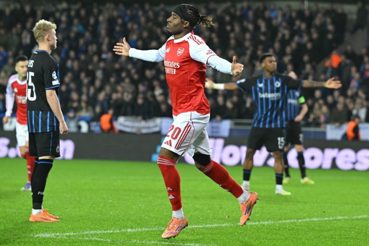 Arsenal's English forward #20 Noni Madueke (C) celebrates after scoring the Arsenal's second goal during the UEFA Champions League, league phase - matchday 6, football match between Club Brugge and Arsenal at the Jan Breydel stadium in Bruges on December 10, 2025.  NICOLAS TUCAT / AFP