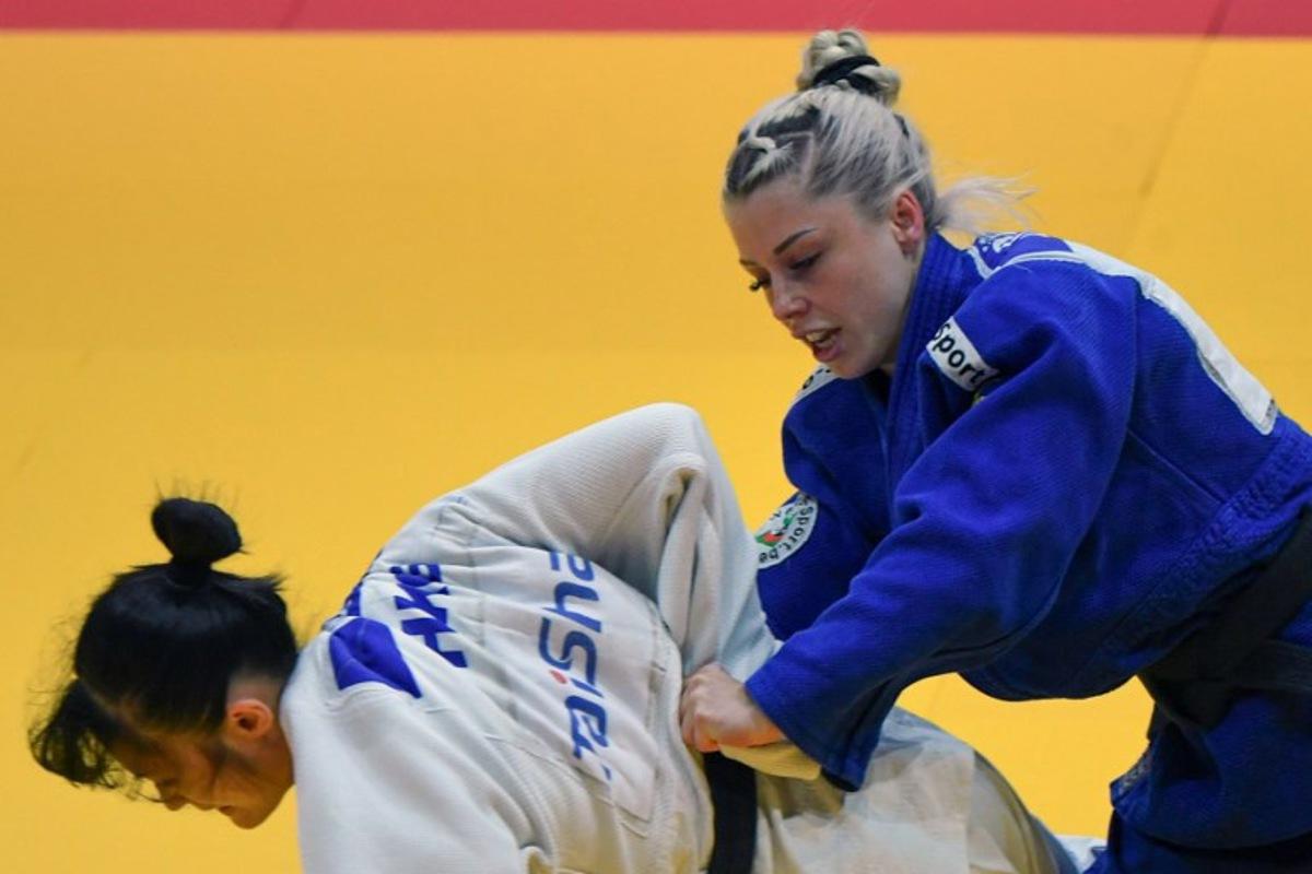 Hong Kong's Wong Ka Lee fights against Belgium's Lois Petit (blue) in the women's -48kg qualification round bout of the Judo World Championships at the Papp Laszlo Arena in Budapest, Hungary on June 13, 2025.  Ferenc ISZA / AFP