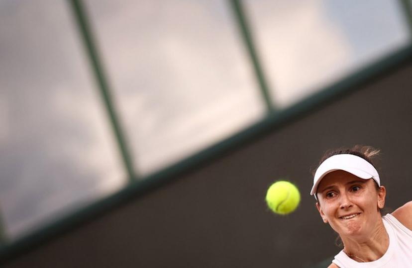 Romania's Irina-Camelia Begu eyes the ball as she returns it to Australia's Daria Kasatkina during their women's singles second round tennis match on the fourth day of the 2025 Wimbledon Championships at The All England Lawn Tennis and Croquet Club in Wimbledon, southwest London, on July 3, 2025.  HENRY NICHOLLS / AFP