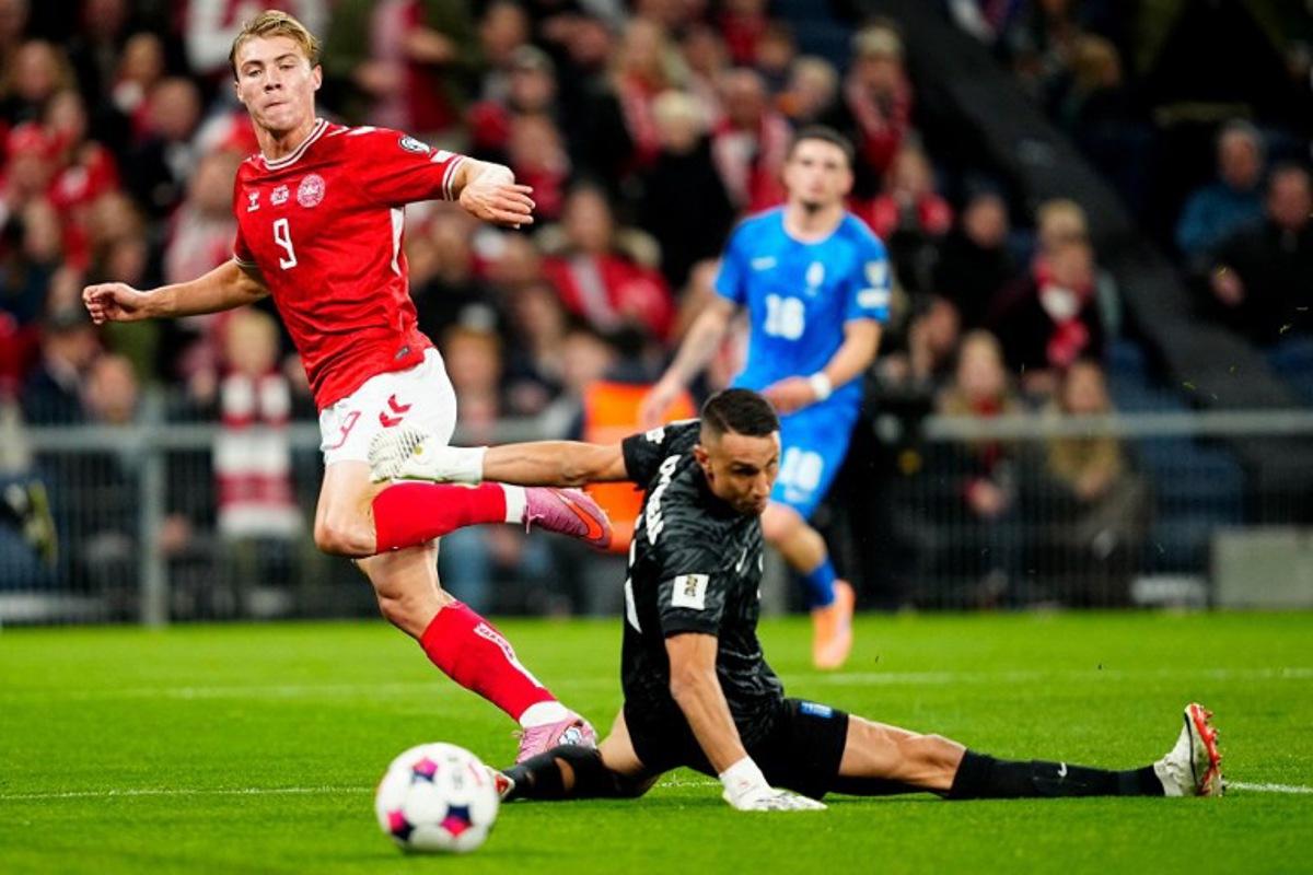 Denmark's forward #09 Rasmus Hojlund (L) scores the opening goal past Greece's goalkeeper #01 Odisseas Vlachodimos during the 2026 World Cup qualifiers Europe zone group G football match between Denmark and Greece on October 12, 2025 in Copenhagen.   Mads Claus Rasmussen / Ritzau Scanpix / AFP