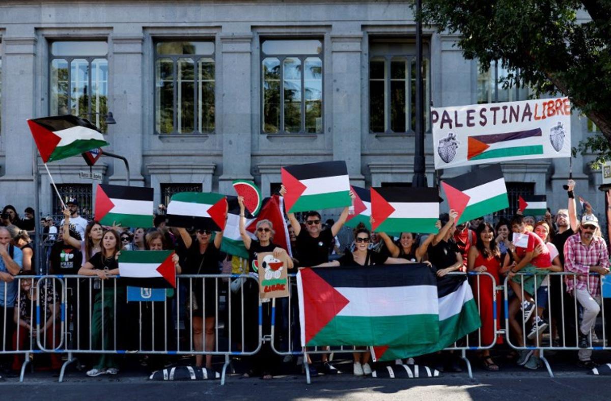 Pro-Palestinians protestors hold Palestinian flags during the 21st and last stage of the Vuelta a Espana 2025, a 101 km race between Alalpardo and Madrid, near Madrid's Cibeles fountain on September 14, 2025.   The authorities have ramped up security for the Vuelta's final stage in Madrid, which was slightly shortened and will see 1,100 police officers deploy in the Spanish capital. Oscar DEL POZO / AFP