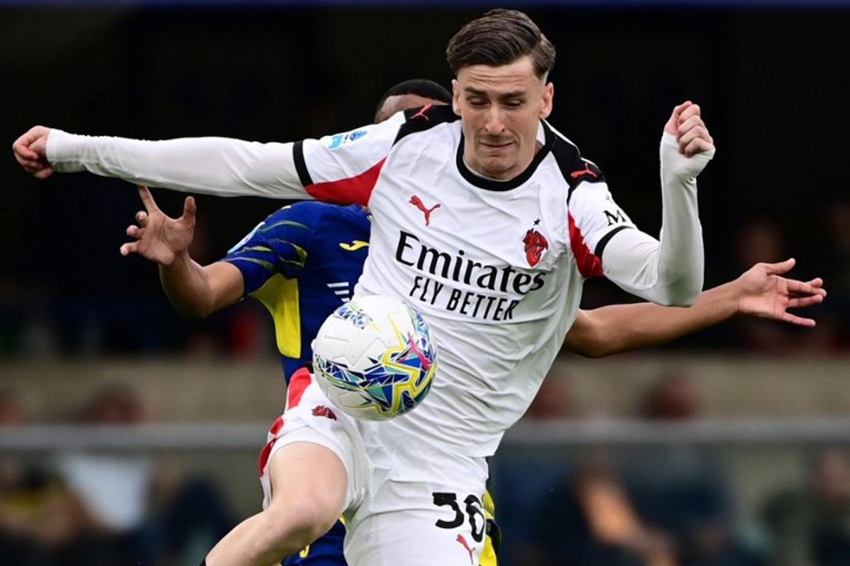 AC Milan's Belgian midfielder #56 Alexis Saelemaekers fights for the ball with Hellas Verona's defender #07 Rafik Belghali during the Italian Serie A football match between Hellas Verona and AC Milan at the  Marcantonio Bentegodi stadium in Verona, on April 19, 2026.  PIERO CRUCIATTI / AFP