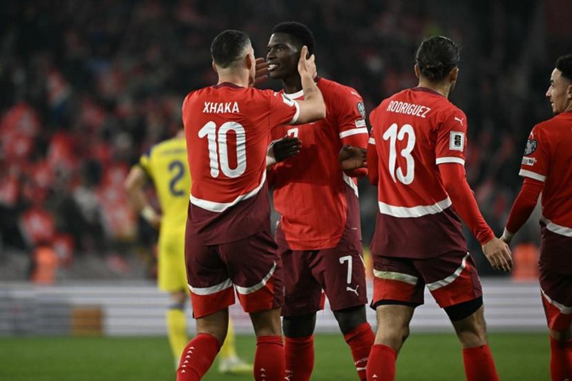 Switzerland's midfielder #10 Granit Xhaka celebrates with Switzerland's forward #07 Breel Embolo after scoring a penalty during the FIFA World Cup 2026 Group B European qualification football match between Switzerland and Sweden at the Geneva stadium, in Geneva, on November 15, 2025.  Fabrice COFFRINI / AFP