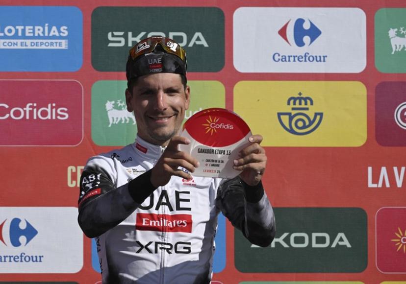 Stage winner, team UAE's Portuguese rider Joao Almeida celebrates on the podium after the 13th stage of the Vuelta a Espana, a 202 km race between Cabezon de la Sal and L'Angliru, on September 5, 2025.    Miguel RIOPA / AFP