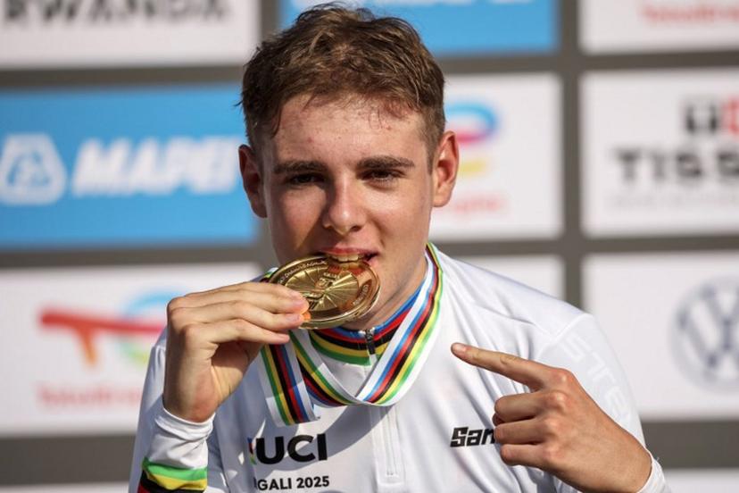 Gold medallist Italian rider Lorenzo Mark Finn bites on his medal on the podium following the men's U23 road race cycling event during the UCI 2025 Road World Championships, in Kigali, on September 26, 2025.  Anne-Christine POUJOULAT / AFP