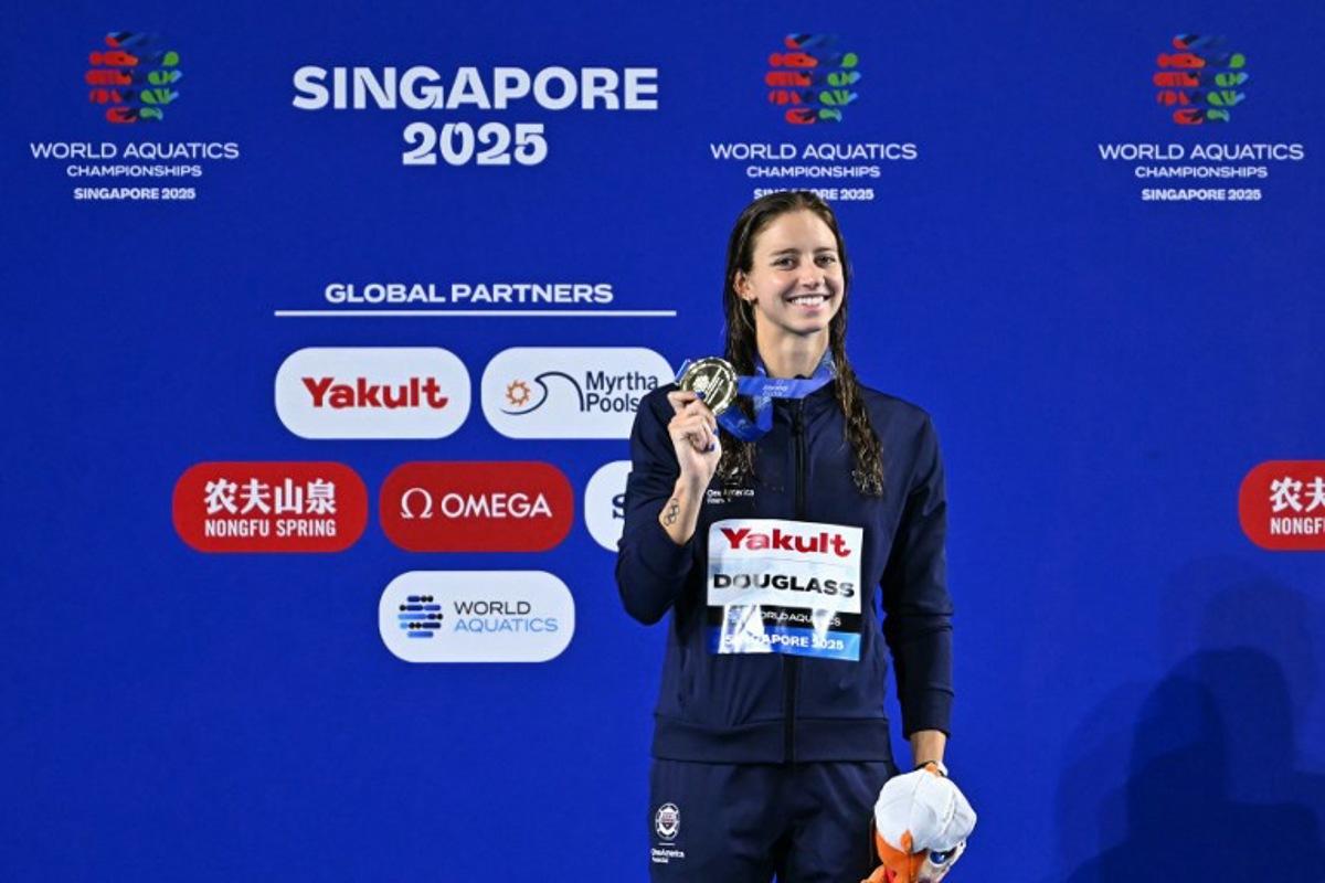 Gold medallist US' swimmer Kate Douglass celebrates on the podium of the women's 200m breaststroke swimming event during the 2025 World Aquatics Championships in Singapore on August 1, 2025.  MANAN VATSYAYANA / AFP