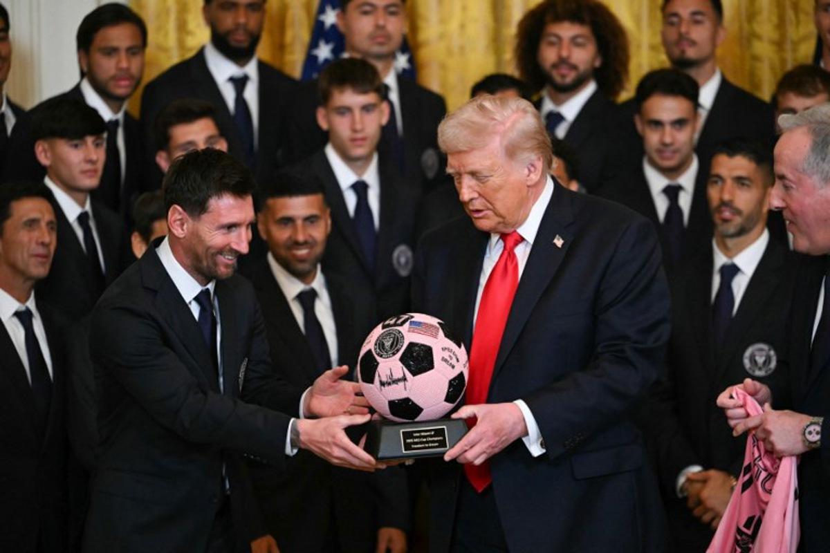 Argntinian star Lionel Messi hands US President Donald Trump a ball during an event for Inter Miami CF, winners of the 2025 Major League Soccer Cup, in the East Room of the White House in Washington, DC, on March 5, 2026.  ANDREW CABALLERO-REYNOLDS / AFP