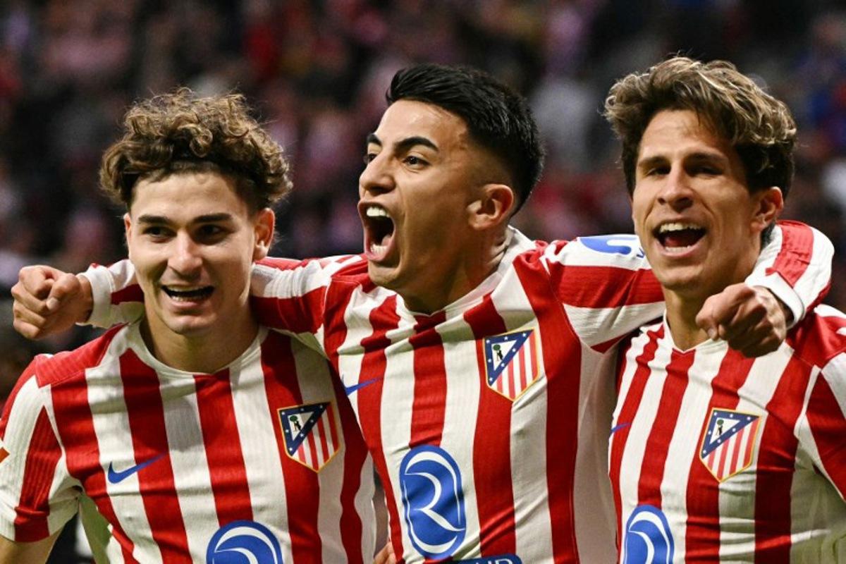 Atletico Madrid's Argentine midfielder #11 Thiago Almada (C) celebrates scoring his team's second goal with Atletico Madrid's Argentine forward #19 Julian Alvarez (L) and Atletico Madrid's Argentine forward #20 Giuliano Simeone during the Spanish League football match between Club Atletico de Madrid and Sevilla FC at Metropolitano Stadium in Madrid on November 1, 2025.  JAVIER SORIANO / AFP