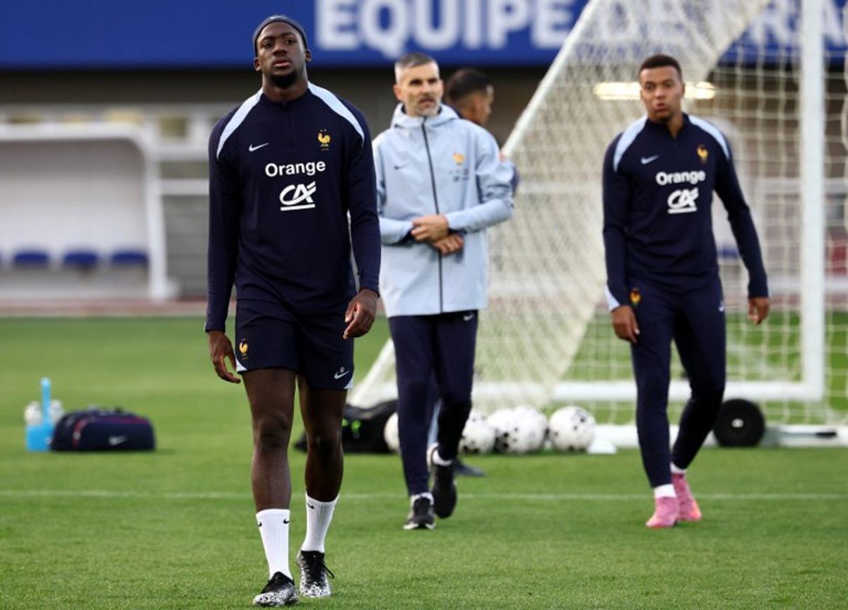 France's defender #24 Ibrahima Konate (L) and France's forward #10 Kylian Mbappe (R) react after stopping his training next to France's physical trainer Cyril Moine (C) as part preparations for upcoming FIFA World Cup 2026 Group D European qualification football matches, at the team's training grounds in Clairefontaine-en-Yvelines, southwest of Paris, on October 8, 2025.  France will face Azerbaidjan on October 10 and Iceland on October  13.   FRANCK FIFE / AFP