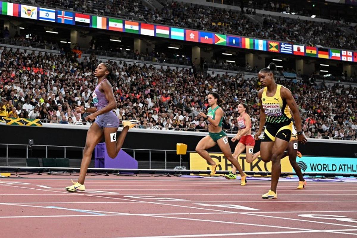 US' athlete Melissa Jefferson-Wooden (L) crosses the finish as she competes in the women's 100m semi-final during the World Athletics Championships in Tokyo on September 14, 2025.  Jewel SAMAD / AFP
