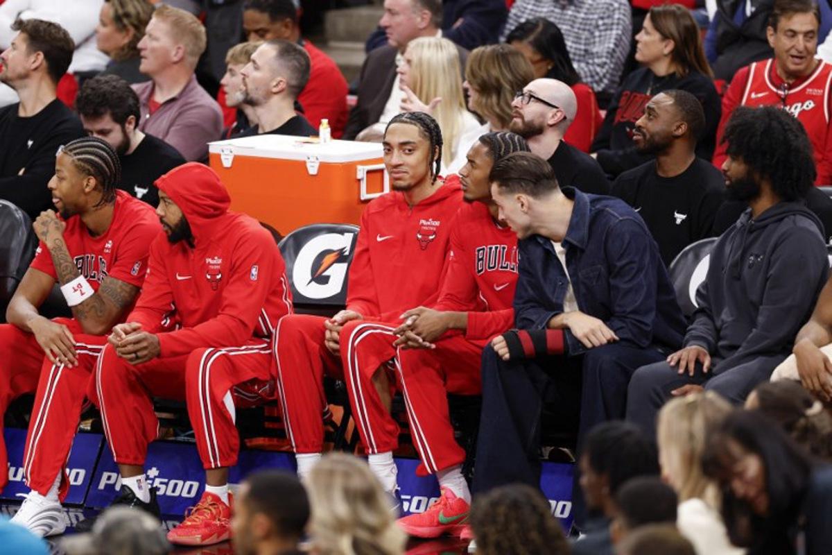 Chicago Bulls' French forward #24 Noa Essengue (C), smiles as he sits on the bench during the first half of an NBA game against the Detroit Pistons at the United Center in Chicago, Illinois, on October 22 2025.  KAMIL KRZACZYNSKI / AFP