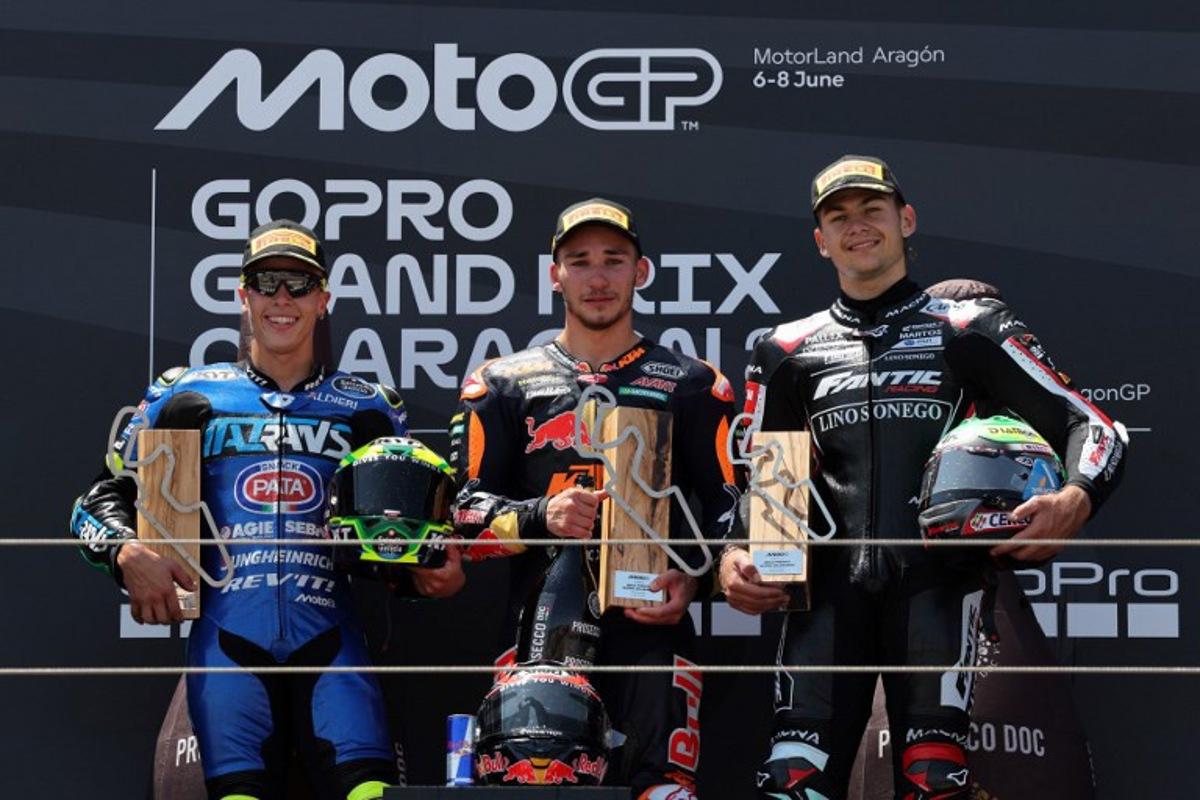 Winner Red Bull KTM Ajo's Deniz Oncu (C), second placed Italtrans Racing Team's Brazilian rider Diogo Moreira (L) and third placed Fantic Racing's Belgian rider Barry Baltus celebrate on the podium after the Moto2 race of the MotoGP Aragon Grand Prix at the Motorland circuit in Alcaniz, northeastern Spain, on June 8, 2025.   LLUIS GENE / AFP