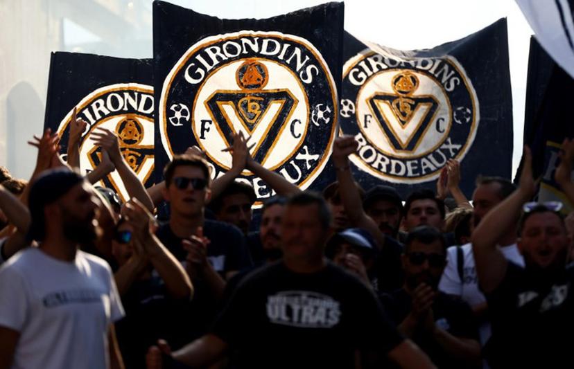 Supporters of French 'Nationale 2' fourth-tier club FC Girondins de Bordeaux wave the club's flags during a protest ahead of a hearing at the Direction Nationale du Controle de Gestion - DNGG, French football financial watchdog, following the six-time French champions' exclusion from national competitions, in Bordeaux, southwestern France July 19, 2026. Unless club officials secure a solution, Girondins de Bordeaux, also three-time French Cup winners, will be relegated to regional-level football following the DNCG's decision. ROMAIN PERROCHEAU / AFP