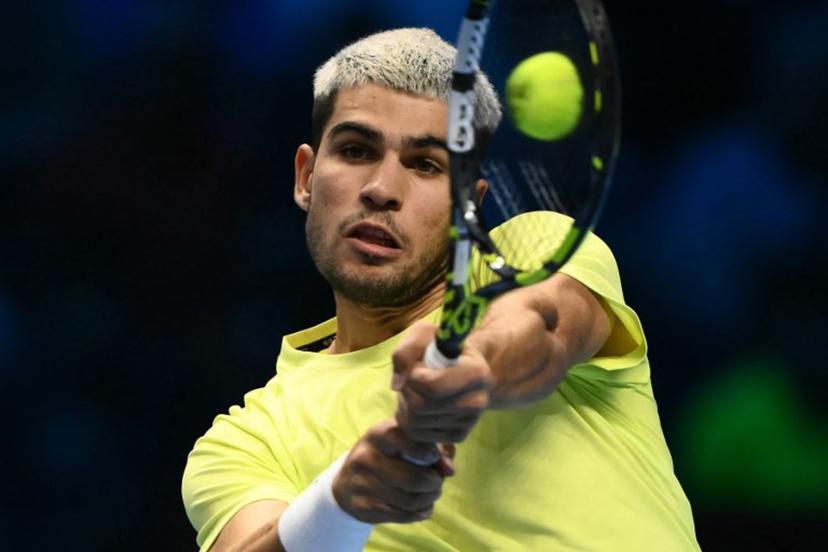 Spain's Carlos Alcaraz hits the ball during his match against Italy's Lorenzo Musetti at the ATP Finals tennis tournament in Turin on November 13, 2025.  Marco BERTORELLO / AFP