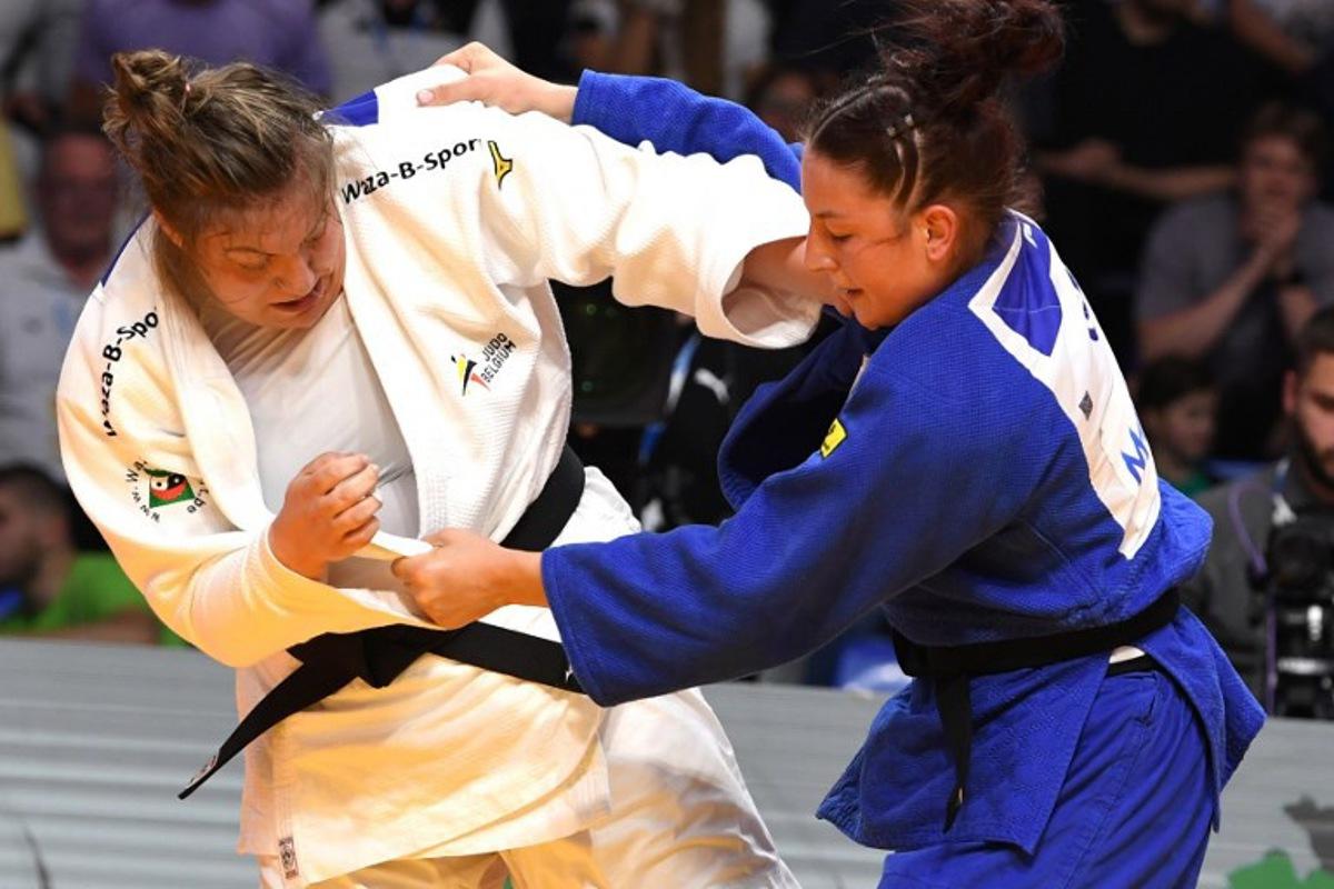 Germany's Anna-Monta Olek (Blue) and Belgium's Gabrielle Bouvier (White) compete in the women's +70 kg bout during the Judo's European Championships in Podgorica, on April 27, 2025. The tournament is taking place from April 23 to 27, 2025.   SAVO PRELEVIC / AFP