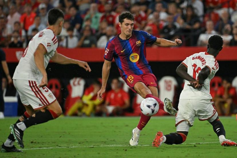 Barcelona's Danish defender #15 Andreas Christensen kicks the ball past Sevilla's Senegalese defender #12 Arouna Sangante during the Spanish league football match between Sevilla FC and FC Barcelona at the Ramon Sanchez Pizjuan stadium in Seville on September 19, 2026.  JORGE GUERRERO / AFP