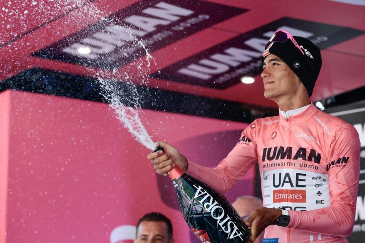 UAE Team Emirates XRG's Mexican rider Isaac Del Toro wearing the pink jersey of overall leader (Maglia Rosa) sprays champagne as he celebrates on the podium after placed second in the 19th stage of the 108th Giro d'Italia cycling race of 166kms from Biella to Champoluc on May 30, 2025.  Luca Bettini / AFP