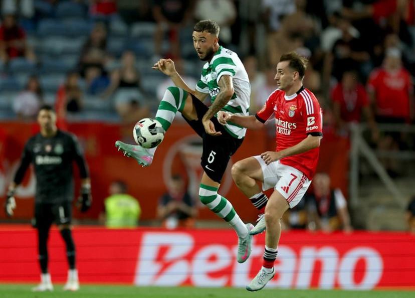 Sporting Lisbon's Belgian defender #06 Zeno Debast is challenged by Benfica's Turkish midfielder #07 Muhammed Akturkoglu during Portugal's Candido de Oliveira Super Cup football final match between Sporting CP and SL Benfica at Algarve Stadium in Loule, southern Portugal, on July 31, 2025.  CARLOS COSTA / AFP