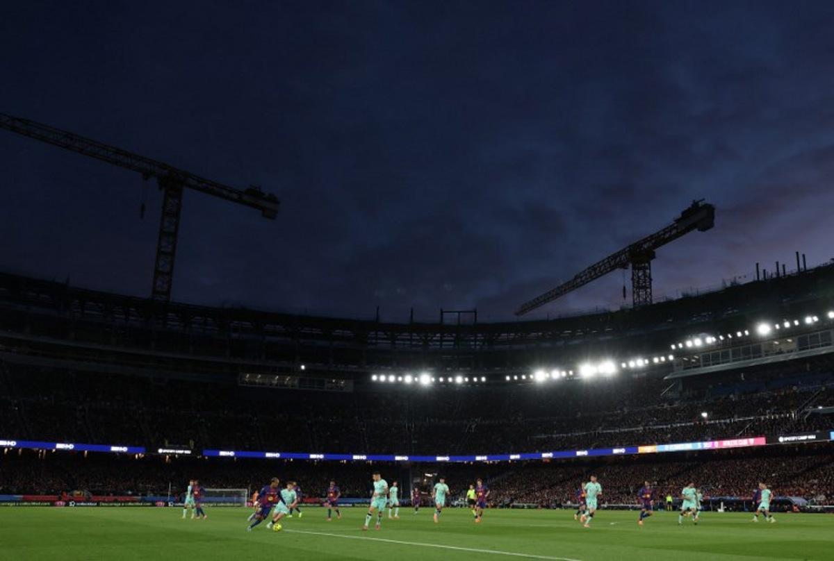 A picture taken on November 22, 2025 shows cranes in background during the Spanish league football match between FC Barcelona and Athletic Club Bilbao at Camp Nou Stadium in Barcelona, still partially under construction.  Lluis GENE / AFP