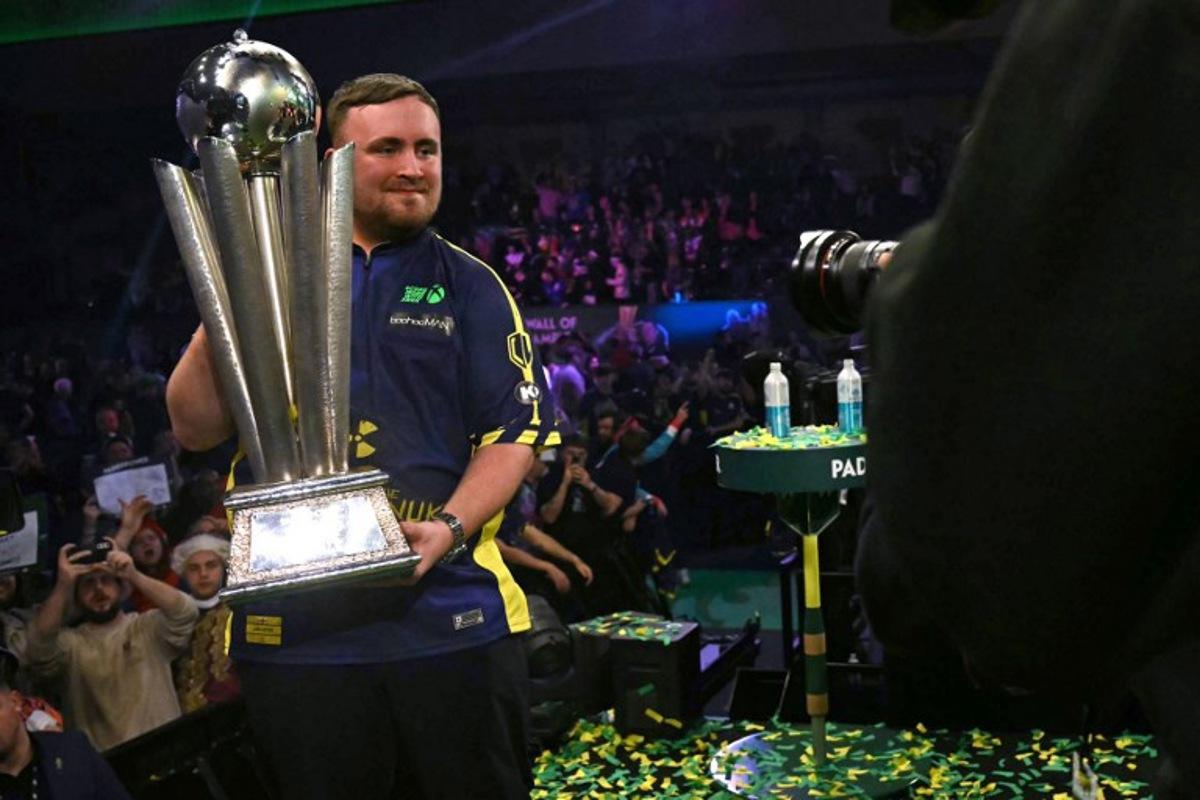 England's Luke Littler poses with the Sid Waddell Trophy after victory over Netherlands' Michael van Gerwen in the PDC World Darts Championship final, at Alexandra Palace in London on January 3, 2025. Luke Littler became darts' youngest world champion at just 17 after thrashing three-time winner Michael van Gerwen in front of an adoring home crowd at London's Alexandra Palace on Friday. This time there was no stopping "Luke the Nuke" as he stormed past Dutchman Van Gerwen by seven sets to three. Ben STANSALL / AFP