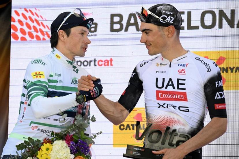 First placed Team Bora's Primoz Roglic (L) shakes hands with second placed Team UAE's Juan Ayuso during the victory ceremony of the 2025 Volta a Catalunya cycling tour of Catalonia race, on March 30, 2025. Roglic won the Vuelta a Catalunya on Sunday, soloing through the seventh and final stage in Barcelona, where his main rival Juan Ayuso (UAE) fell behind in the final. Roglic, who was a second behind Ayuso at the start of this final stage, broke away with 20 km to go and managed to maintain his lead to secure his second Volta a Catalunya victory. Josep LAGO / AFP