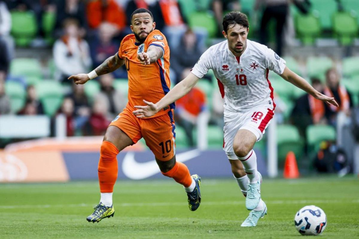 Memphis Depay of the Netherlands (L) fights for the ball with James Carragher of Malta during the World Cup qualifier between the Netherlands and Malta at the Euroborg stadium in Groningen on June 10, 2025.  Koen Van WEEL / ANP / AFP
