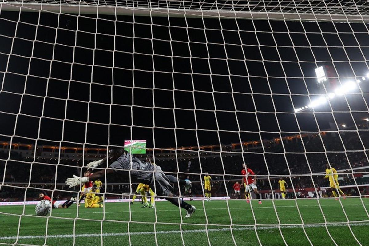 Egypt's forward #10 Mohamed Salah scores past Zimbabwe's goalkeeper #22 Washington Arubi during the Africa Cup of Nations (CAN) group B football match between Egypt and Zimbabwe at Adrar Stadium in Agadir on December 22, 2025.   FRANCK FIFE / AFP