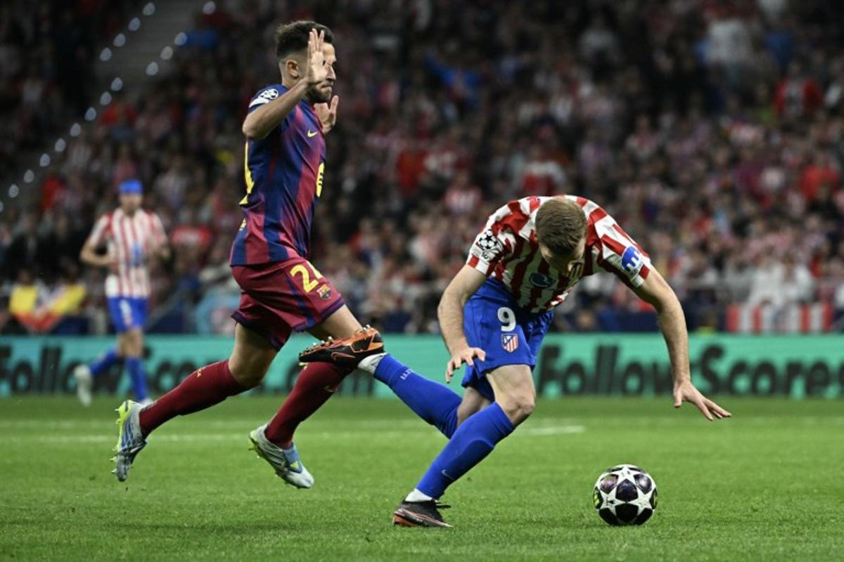 Atletico Madrid's Norwegian forward #09 Alexander Sorloth (R) falls to the ground after colliding with Barcelona's Spanish defender #24 Eric Garcia during the UEFA Champions League quarter final second leg football match between Club Atletico de Madrid and FC Barcelona at Metropolitano Stadium in Madrid on April 14, 2026.  Javier SORIANO / AFP