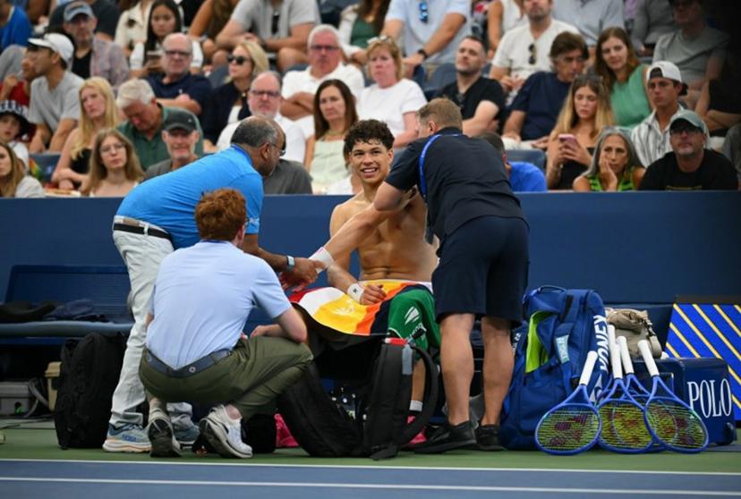 USA's Ben Shelton receives medical attention as he plays France's Adrian Mannarino during their men's singles third round match on day six of the US Open tennis tournament at the USTA Billie Jean King National Tennis Center in New York City on August 29, 2025.  ANGELA WEISS / AFP