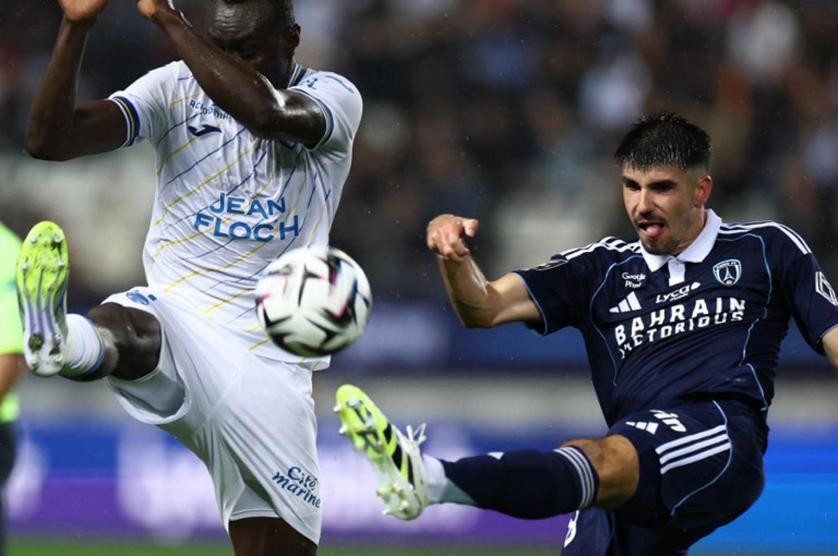 Paris FC's Belgian defender #28 Thibault De Smet (R) shoots the ball past Lorient's Ivorian forward #09 Mohamed Bamba during the French L1 football match between Paris FC and FC Lorient at the Stade Jean-Bouin in Paris on October 3, 2025.  FRANCK FIFE / AFP