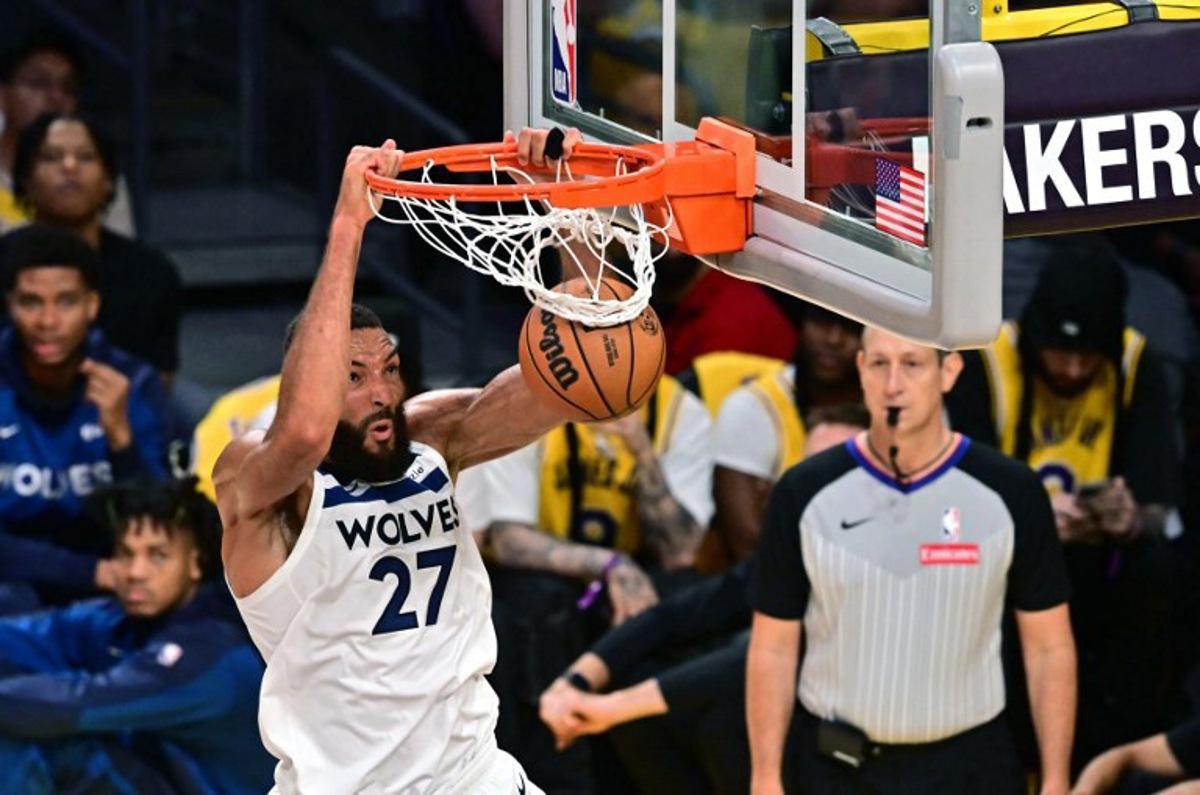 Minnesota Timberwolves French center #27 Rudy Gobert slam dunks during the NBA game season opener between the Los Angeles Lakers and the Minnesota Timberwolves at Crypto Arena in Los Angeles on October 22, 2024. LeBron and Bronny are the first father and son to play together in any NBA game. Frederic J. BROWN / AFP
