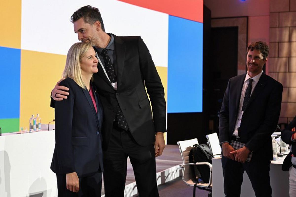 Zimbabwean candidate for the presidency of the International Olympic Committee (IOC) Kirsty Coventry (L) is congratulated by Former Spanish basketball player Pau Gasol (C) after being elected during the 144th IOC Session on the day of the election of the next President of the International Olympic Committee (IOC), in Costa Navarino, Greece on March 20, 2025. Zimbabwe's Kirsty Coventry was elected president of International Olympic Committee on March 20, 2025.  Fabrice COFFRINI / AFP