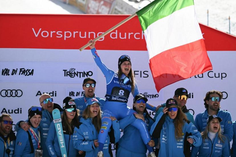 Winner Italy's Laura Pirovano (top C) waves the Italian flag as she poses with team mates after the Women's Downhill race of the FIS Ski World Cup at the La Volata slope in the Passo San Pellegrino ski area, Val di Fassa, Italy on March 6, 2026.  Andreas SOLARO / AFP
