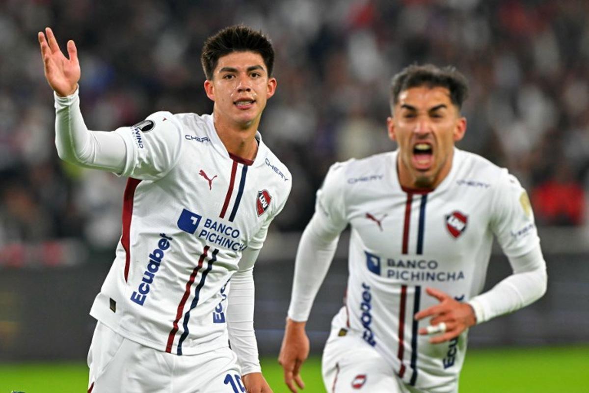 Liga de Quito's Bolivian midfielder #15 Gabriel Villamil (L) celebrates with a teammate scoring his team's first goal during the Copa Libertadores semifinal first leg football match between Ecuador's Liga de Quito and Brazil's Palmeiras at the Rodrigo Paz Delgado stadium in Quito on October 23, 2025.  Rodrigo BUENDIA / AFP
