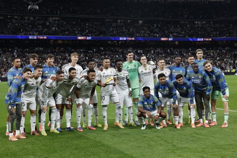Real Madrid's French forward #10 Kylian Mbappe (C) holds his Golden Shoe trophy as he poses with teammates before the Spanish League football match between Real Madrid CF and Valencia CF at Santiago Bernabeu Stadium in Madrid on November 1, 2025.  Oscar DEL POZO / AFP