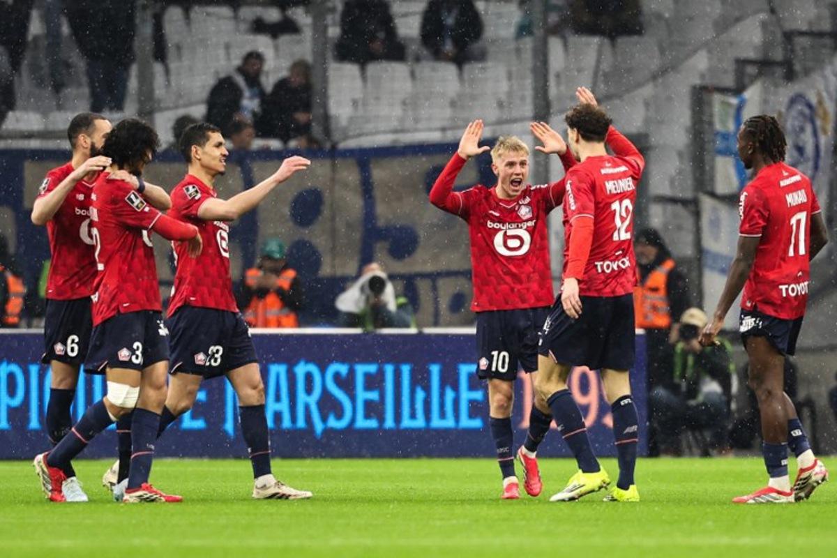 Lille's Belgian defender #12 Thomas Meunier (2R) celebrates with Lille's Icelandic midfielder #10 Hakon Arnar Haraldsson (3R) and teammates after scoring his team first goal during the French L1 football match between Olympique de Marseille (OM) and Lille OSC at the Stade Velodrome in Marseille, southern France on March 22, 2026.  Pascal POCHARD-CASABIANCA / AFP