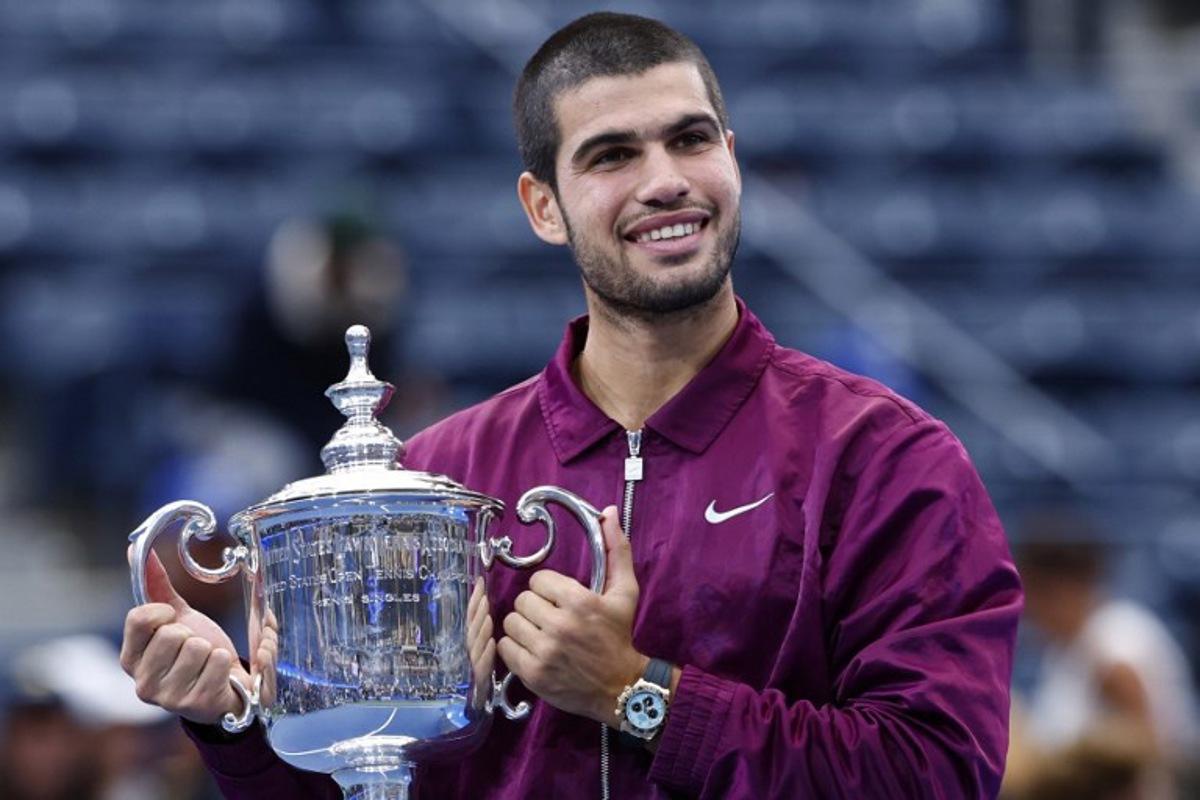 Spain's Carlos Alcaraz celebrates with his trophy after defeating Italy's Jannik Sinner in the men's singles final tennis match on day fifteen of the US Open tennis tournament at the USTA Billie Jean King National Tennis Center in New York City on September 7, 2025. Carlos Alcaraz beat Jannik Sinner in four sets on Sunday to win the US Open as loud boos -- mixed with a smattering of cheers -- greeted President Donald Trump at the final in New York.  KENA BETANCUR / AFP