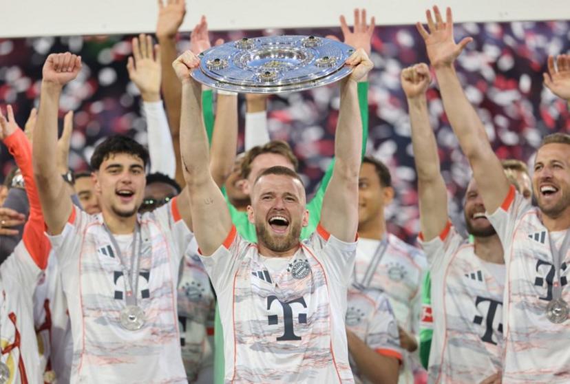 Bayern Munich's English defender #15 Eric Dier lifts the trophy after the German first division Bundesliga football match between Bayern Munich and Borussia Moenchengladbach in Munich on May 10, 2025.  Alexandra BEIER / AFP