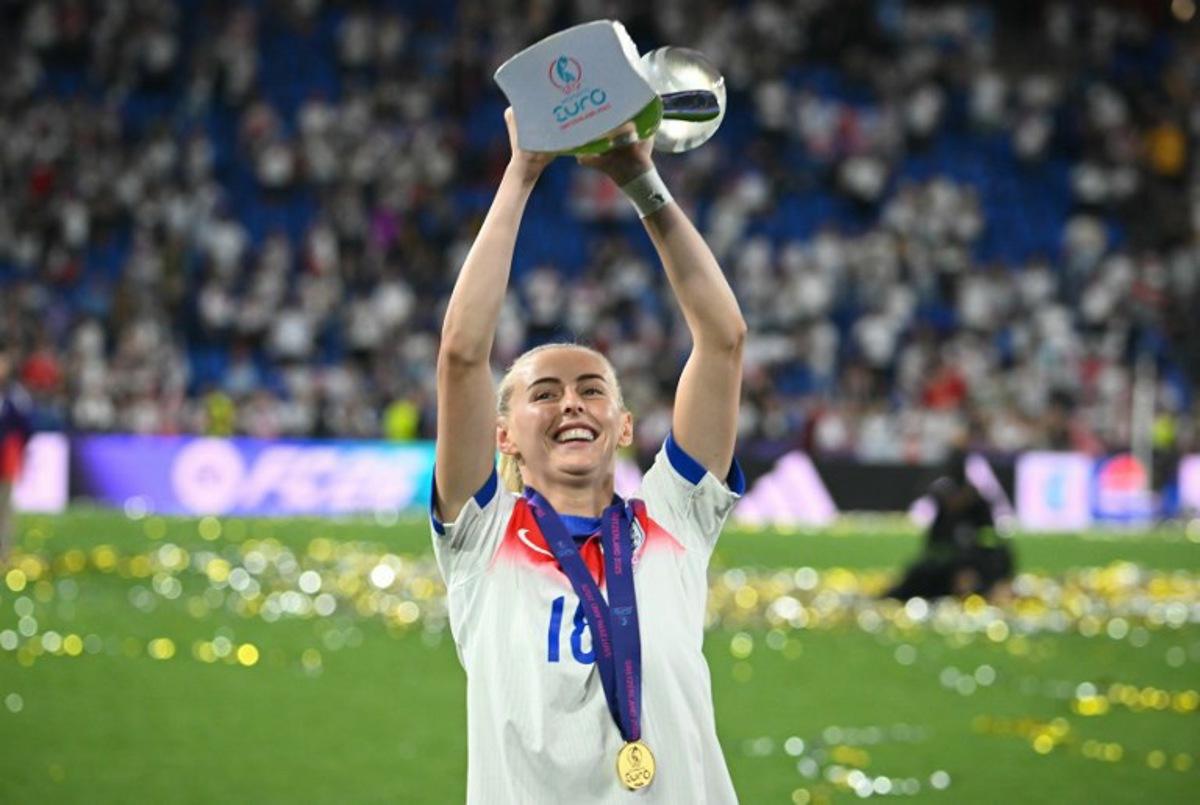 England's forward #18 Chloe Kelly celebrates as she holds the trophy up after England won the UEFA Women's Euro 2025 final football match between England and Spain at the St. Jakob-Park Stadium in Basel, on July 27, 2025. Chloe Kelly converted the decisive kick as England beat Spain 3-1 on penalties to lift the Women's Euro 2025 trophy after the game had finished 1-1 at the end of extra time, allowing the Lionesses to avenge their defeat in the World Cup final two years ago and retain their continental crown. SEBASTIEN BOZON / AFP