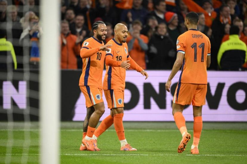 Netherlands' forward #18 Donyell Malen (C) celebrates after scroing the Netherlands fourth goal with Netherlands' forward #10 Memphis Depay (L) and Netherlands' forward #11 Cody Gakpo (R) during the FIFA World Cup 2026 Group G European qualification football match between the Netherlands and Lithuania at the Johan Cruijff Arena, in Amsterdam, on November 17, 2025.  JOHN THYS / AFP