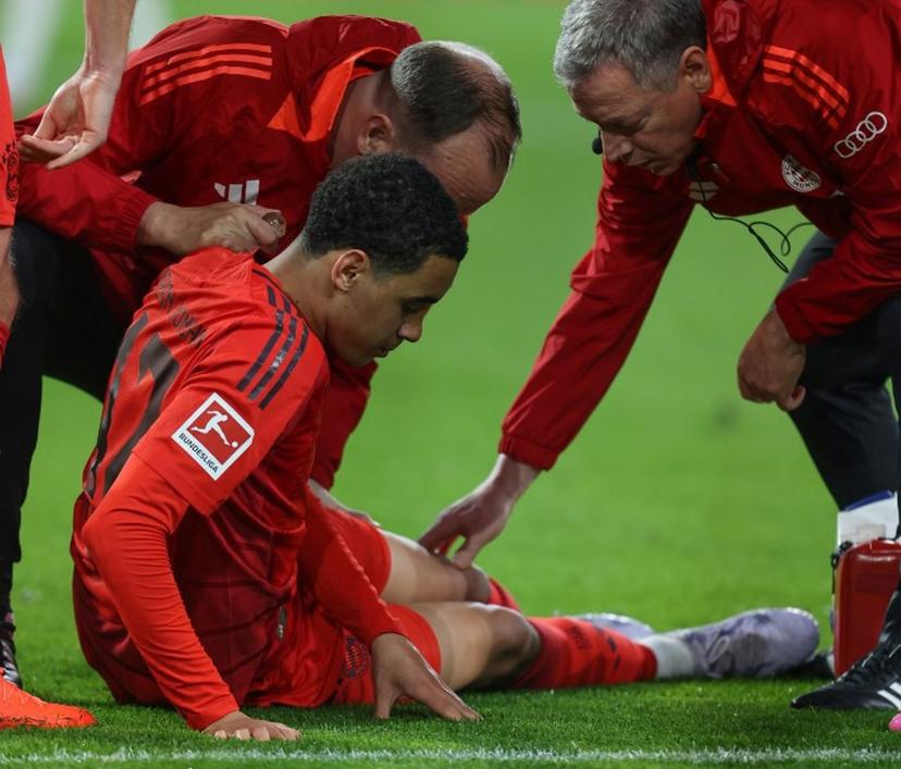 Bayern Munich's German midfielder #42 Jamal Musiala receives medical attention after sustaining an injury during the German first division Bundesliga football match between FC Augsburg and FC Bayern Munich in Augsburg, southern Germany, on April 4, 2025.  Alexandra BEIER / AFP