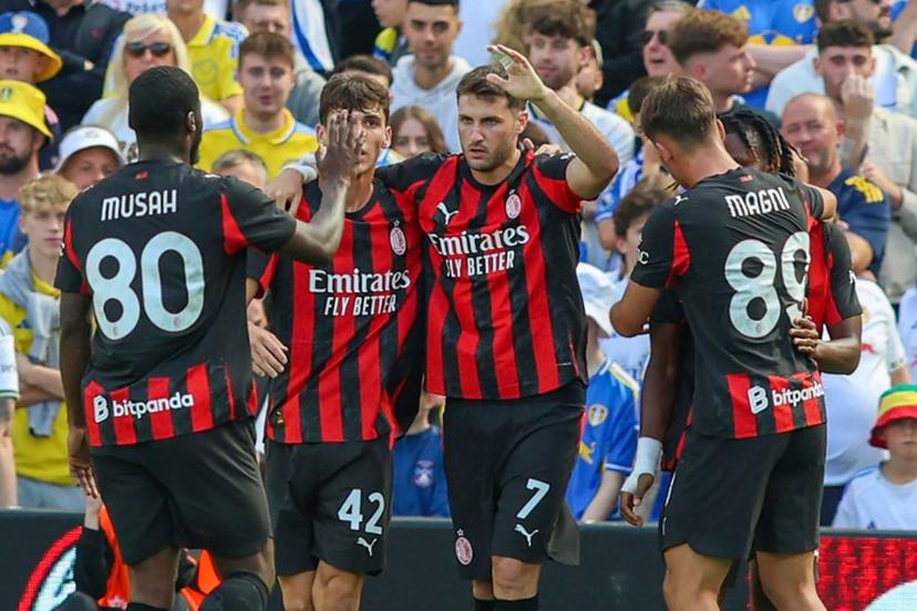 AC Milan's Mexican striker #07 Santiago Gimenez (C) celebrates with teammates after scoring the opening goal during the pre-season friendly football match between Leeds United and AC Milan at the Aviva Stadium in Dublin on August 9, 2025.   Paul Faith / AFP